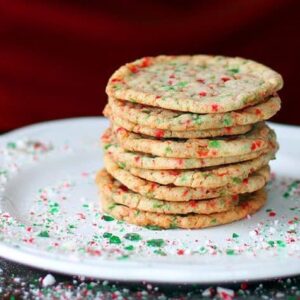 Close up Stack of Buttery Candy Cane Cookies in a White Plate with Crushed Candy Cane