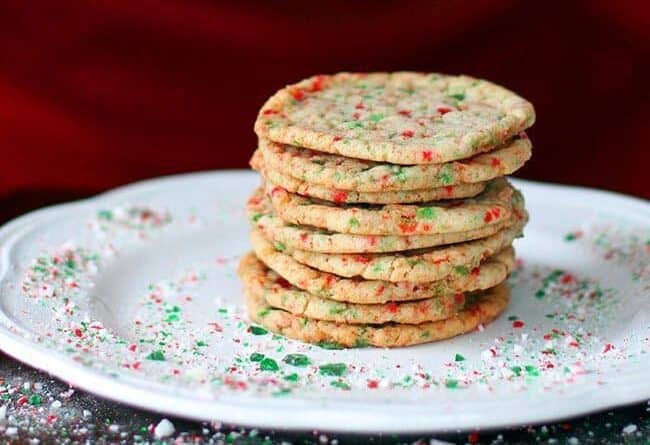 Close up Stack of Buttery Candy Cane Cookies in a White Plate with Crushed Candy Cane