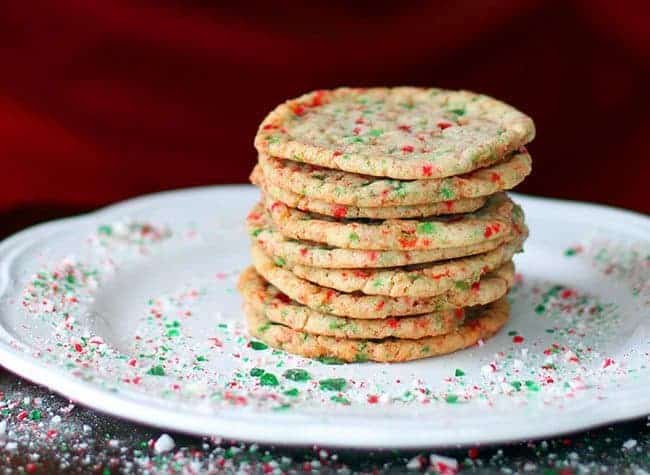 Stack of Buttery Candy Cane Cookies in a White Plate with Crushed Candy Cane