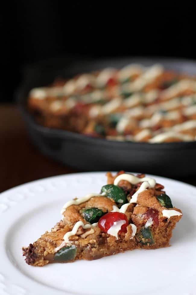 close up slice of Christmas Fruitcake Chocolate Chip Skillet Cookie in a white dessert plate