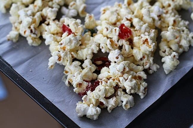 Christmas popcorn covered in white chocolate and tossed with colored cherries and pecans