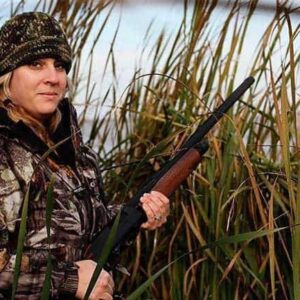 woman wearing her duck hunting gears and holding a riffle for duck hunting