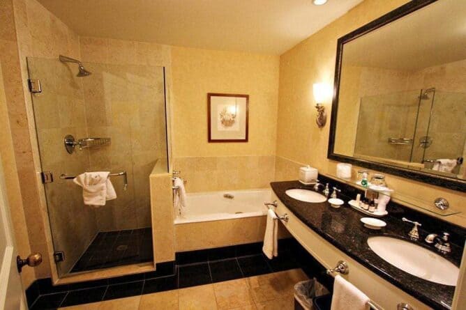 spacious and beautiful bathroom with double sink, glass enclosed shower and a very large soaker tub