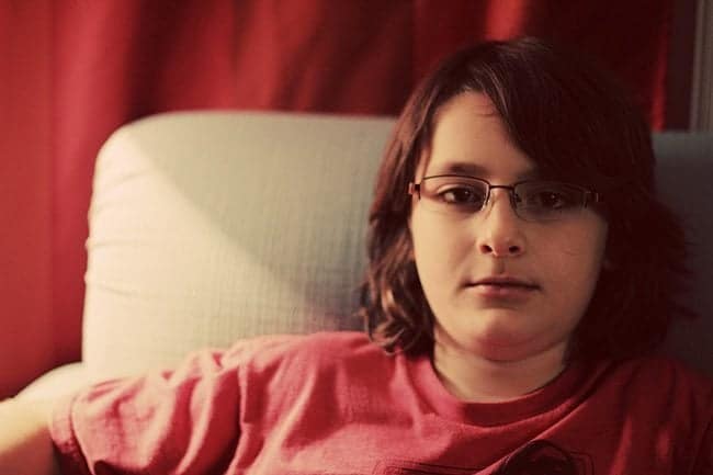 close up of a boy wearing red shirt and his glasses