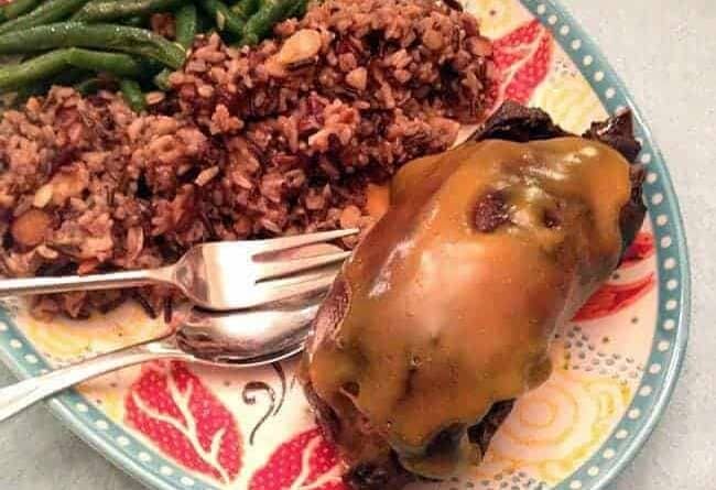 plate with braised wild duck, rice and almond green beans with a delicious orange sauce over it