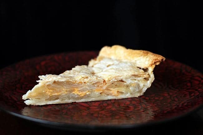 a slice of Scalloped Onion Pie in a red plate