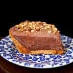 slice of hazelnut chocolate cream pie topped with crushed nuts in a small plate printed with blueberries