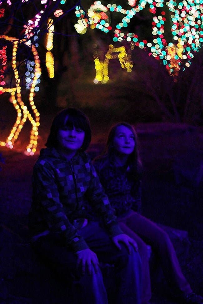 two little children sitting with the background of lighted figure