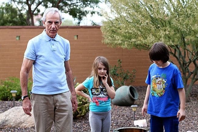 grandfather with his granddaughter and grandson in the house yard