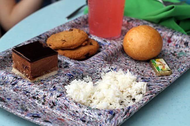 Rice, butter and a bun, dessert and some crazy fruitopia juice in a plate