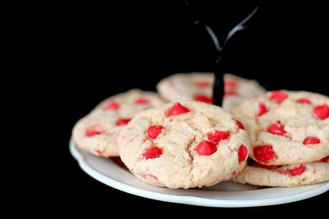 Cherry Cake Mix Cookies in a white cake holder on dark background