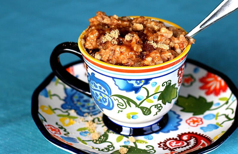 Cinnamon Raisin Slow Cooker Oatmeal topped with brown sugar and maple syrup