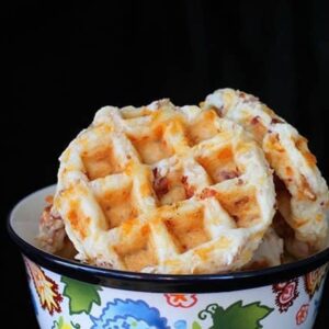 Close up of Bacon & Cheddar Waffle Biscuits in a Colorful Pyrex Bowl