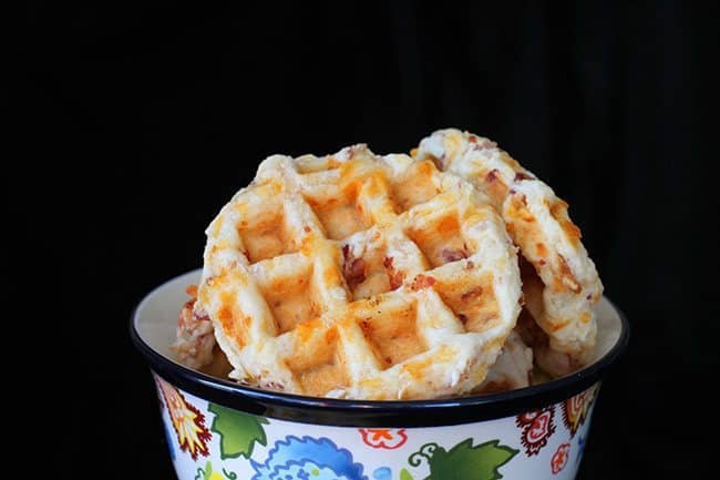 Close up of Bacon & Cheddar Waffle Biscuits in a Colorful Pyrex Bowl