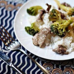 Beef and Broccoli on top of rice in a plate