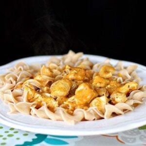 White floral printed tablecloth underneath a plate of Chicken Korma Over Pasta