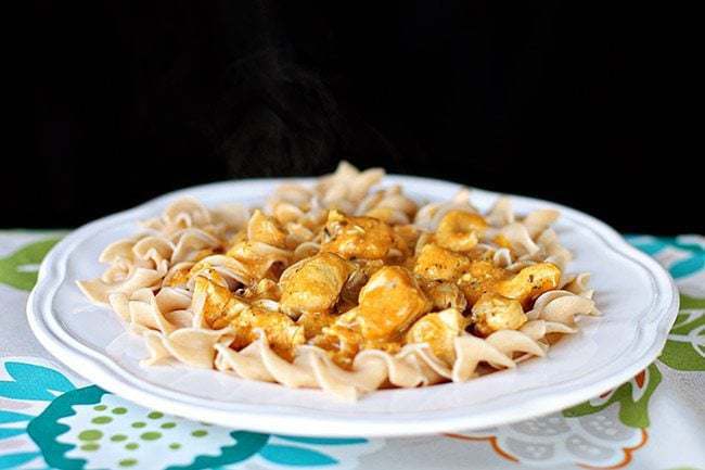 White floral printed tablecloth underneath a plate of Chicken Korma Over Pasta
