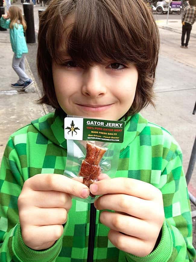 young boy holding a pack of gator jerky