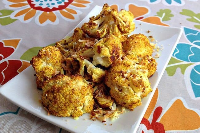 Honey & Curry Cauliflower in a white rectangular serving plate over a floral tablecloth