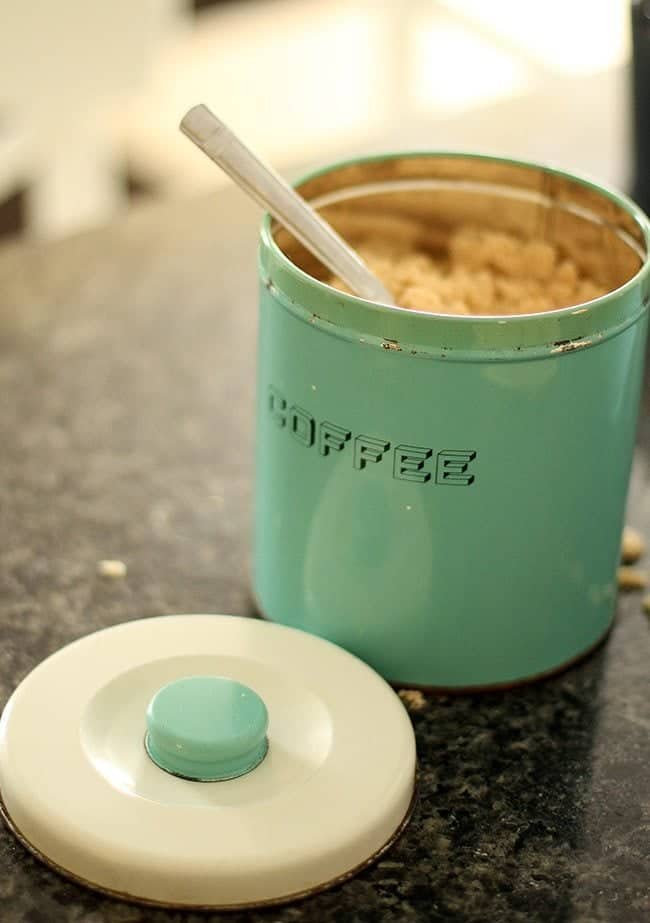 an open large turquoise canister with spoon inside