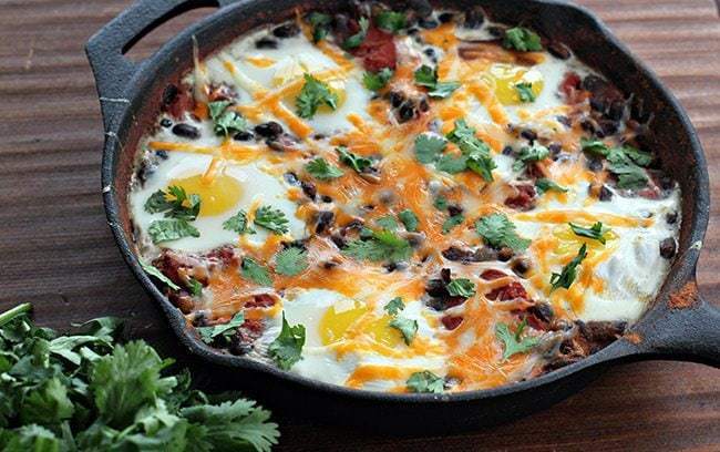 Mexican Bean Breakfast Skillet topped with Cilantro on wood background