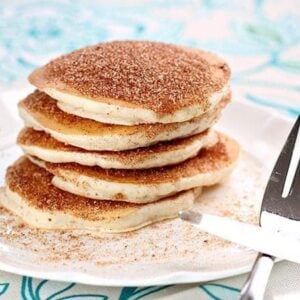 Snickerdoodle Pancakes coated with sugar and cinnamon mixture in a white plate