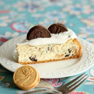 Close up Slice of Cookie Cheesecake topped with whipped cream and Girl Guide Cookie