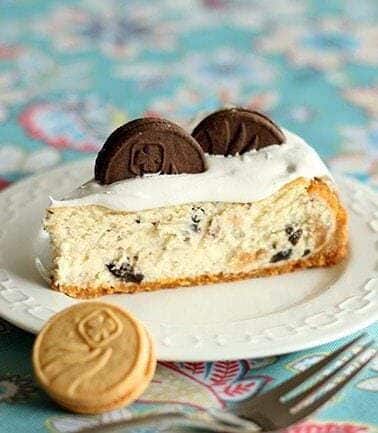 Close up Slice of Cookie Cheesecake topped with whipped cream and Girl Guide Cookie