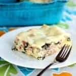 Cheesy Ham & Kale Lasagna serving in a white plate with fork