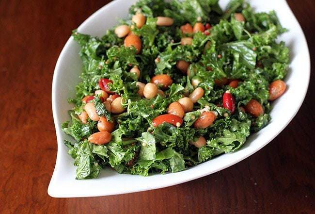 Kale & Mixed Bean Salad with homemade vinaigrette in a white leaf shaped bowl