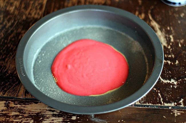 red batter poured into cake tin