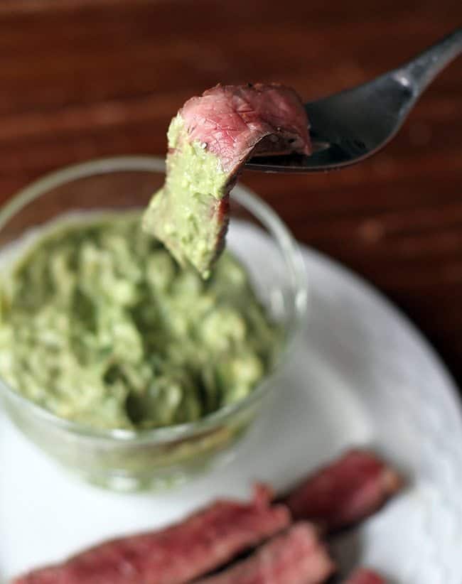 dipping a slice of BBQ steak into Horseradish Guacamole