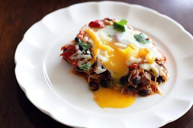 egg dripping in a serving of Steak & Eggs Skillet on white plate