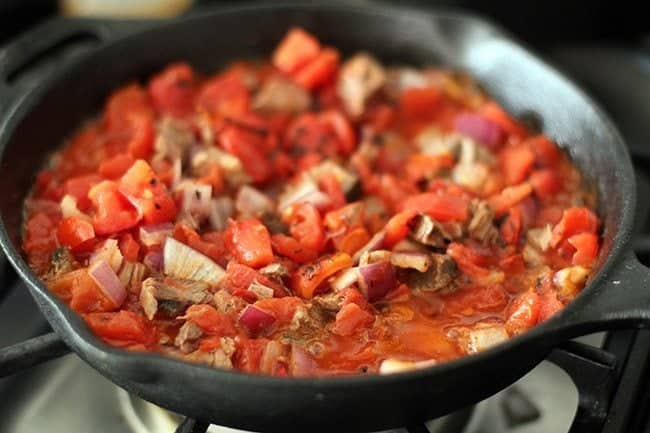 frying the onions, tomatoes, beef, taco seasoning and beans in a large skillet