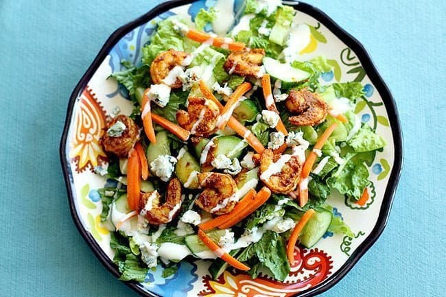 Top down shot of shrimp salad with BBQ curry and blue cheese crumbles