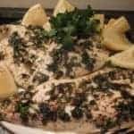 Garlic & Herb Fish with slices of lemon and chopped cilantro