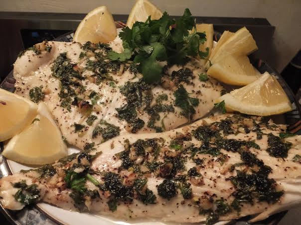 Garlic & Herb Fish with slices of lemon and chopped cilantro