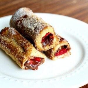 3 pieces of Strawberry Nutella French Toast Rolls in a white plate