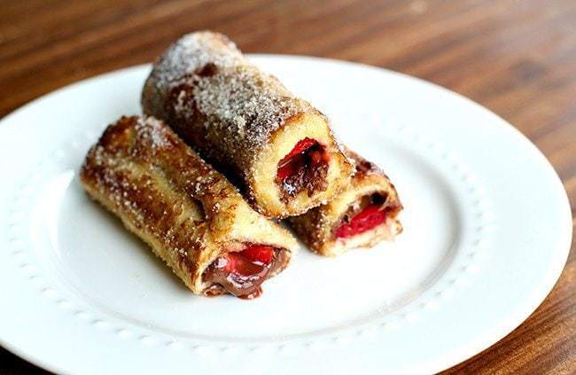 3 pieces of Strawberry Nutella French Toast Rolls in a white plate