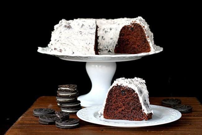 Homemade Double Chocolate Oreo Cake with Oreo Buttercream Icing in a white plate and on a white cake holder