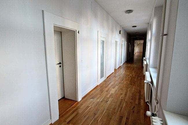 long narrow hallway inside the hotel with walls painted white