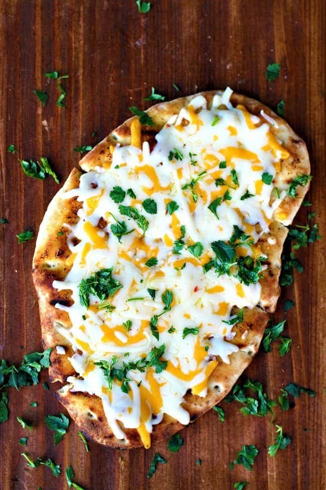 Top down shot of Tex Mex Cheesy Grilled Naan Bread sprinkled with chopped cilantro in a wood background