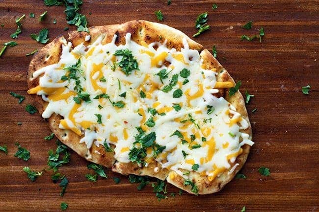 Top down shot of Tex Mex Cheesy Grilled Naan Bread sprinkled with chopped cilantro in a wood background