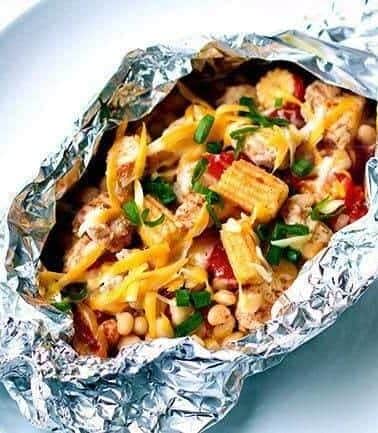 Close up of Chicken Foil Packets on a plate topped with cheese and green onions