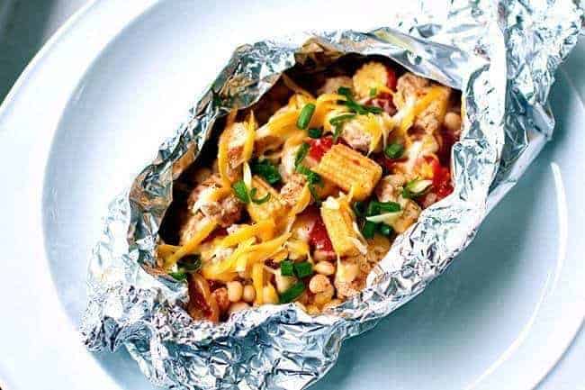 Campfire Tex Mex White Bean Chicken in a tin foil on a white plate