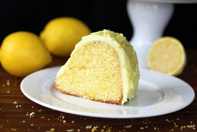a slice of Homemade Lemon Pudding Cake in White plate, fresh lemons on background