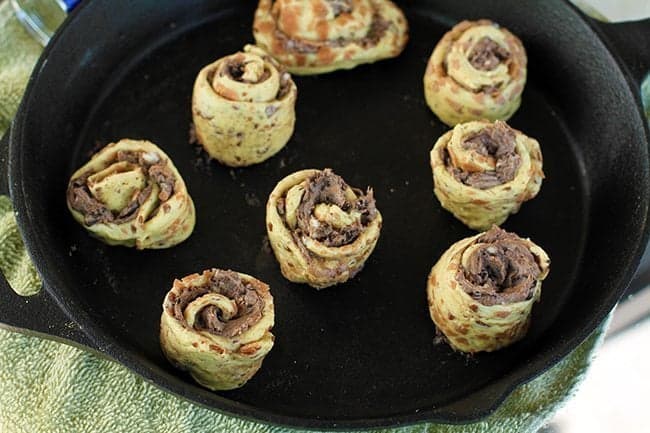 cinnamon buns with cream cheese and Oreo's inside in large skillet