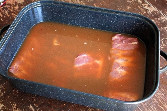 ribs in a large baking pan with BBQ mixture 