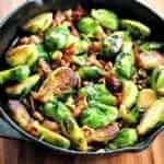 Large frying pan with bacon, walnuts and honey brussels sprouts with melted honey