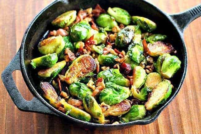 Large frying pan with bacon, walnuts and honey brussels sprouts with melted honey